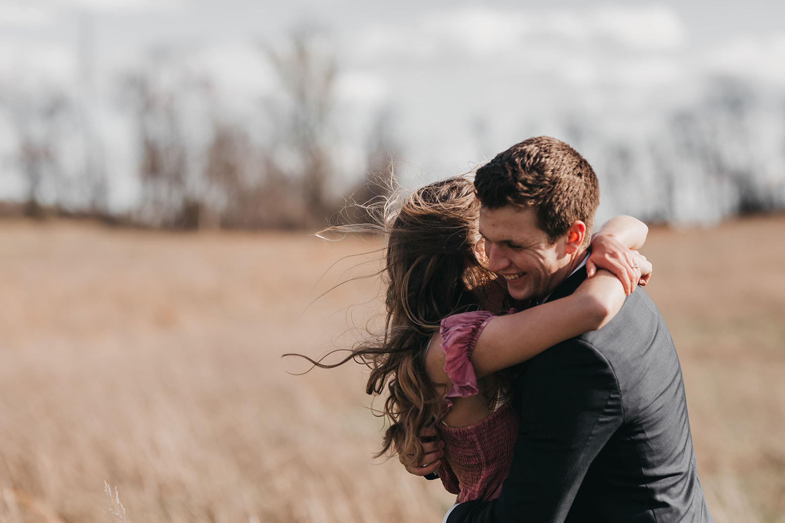 photo of a couple a laughing in a field