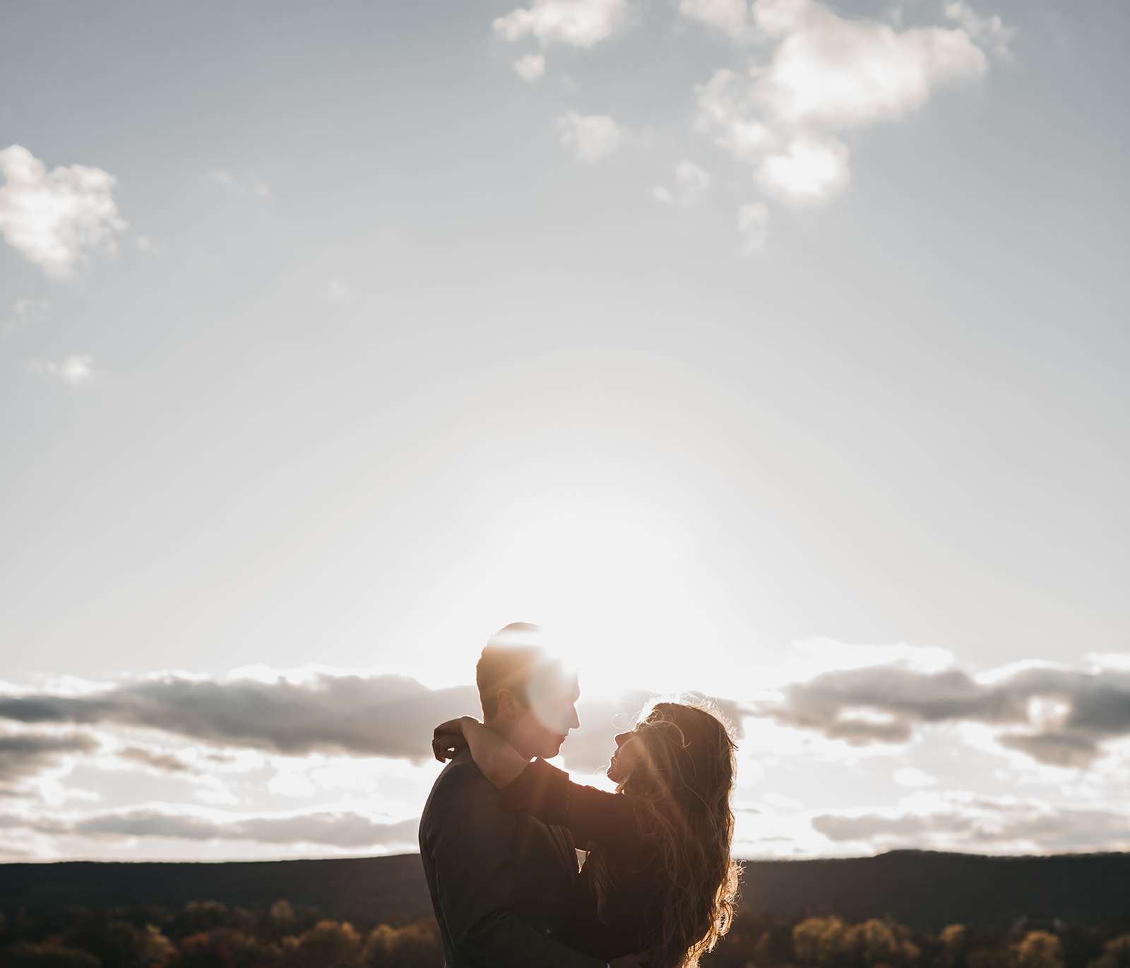photo of a couple in front of a sun