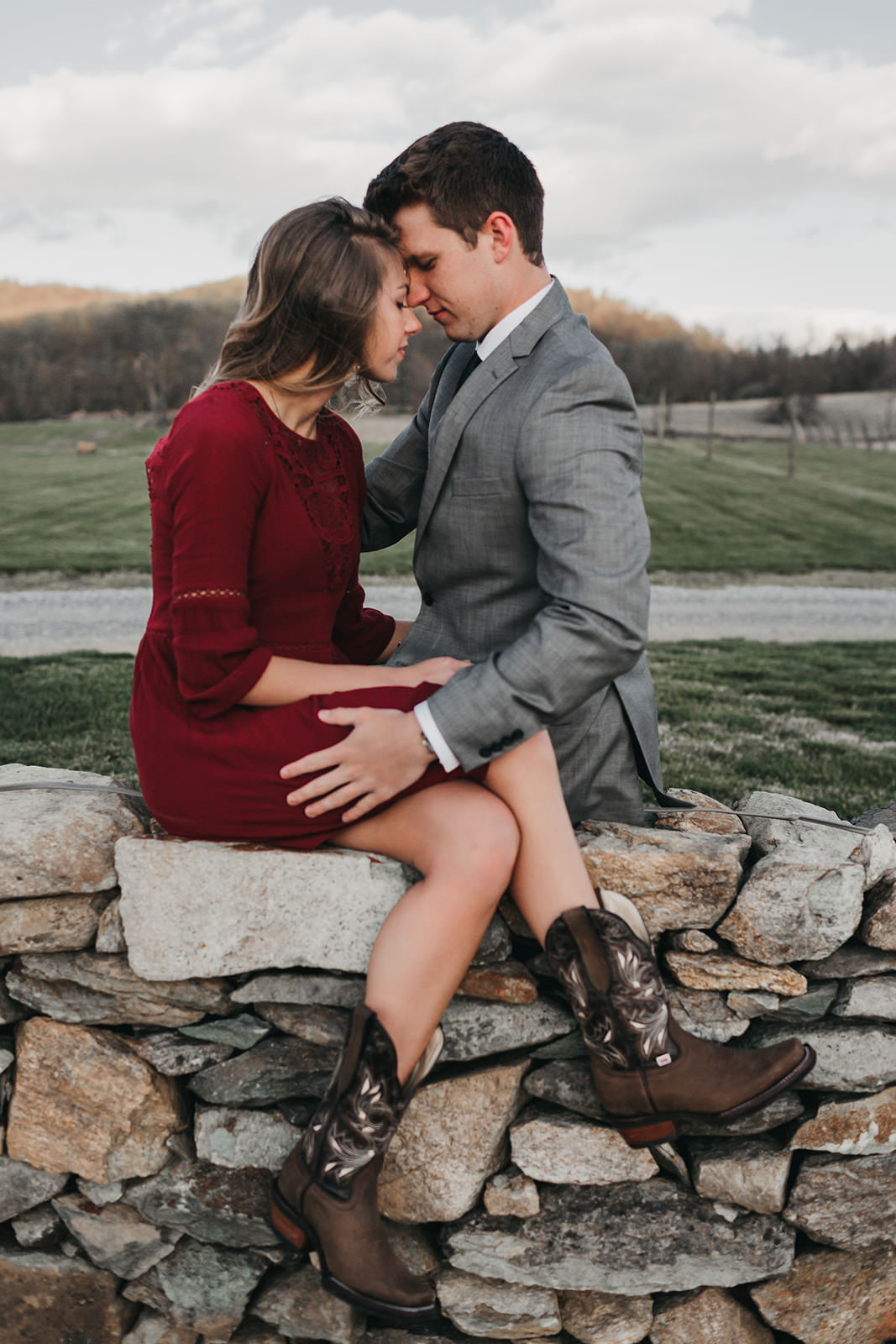 photo of a couple sitting on a stone wall