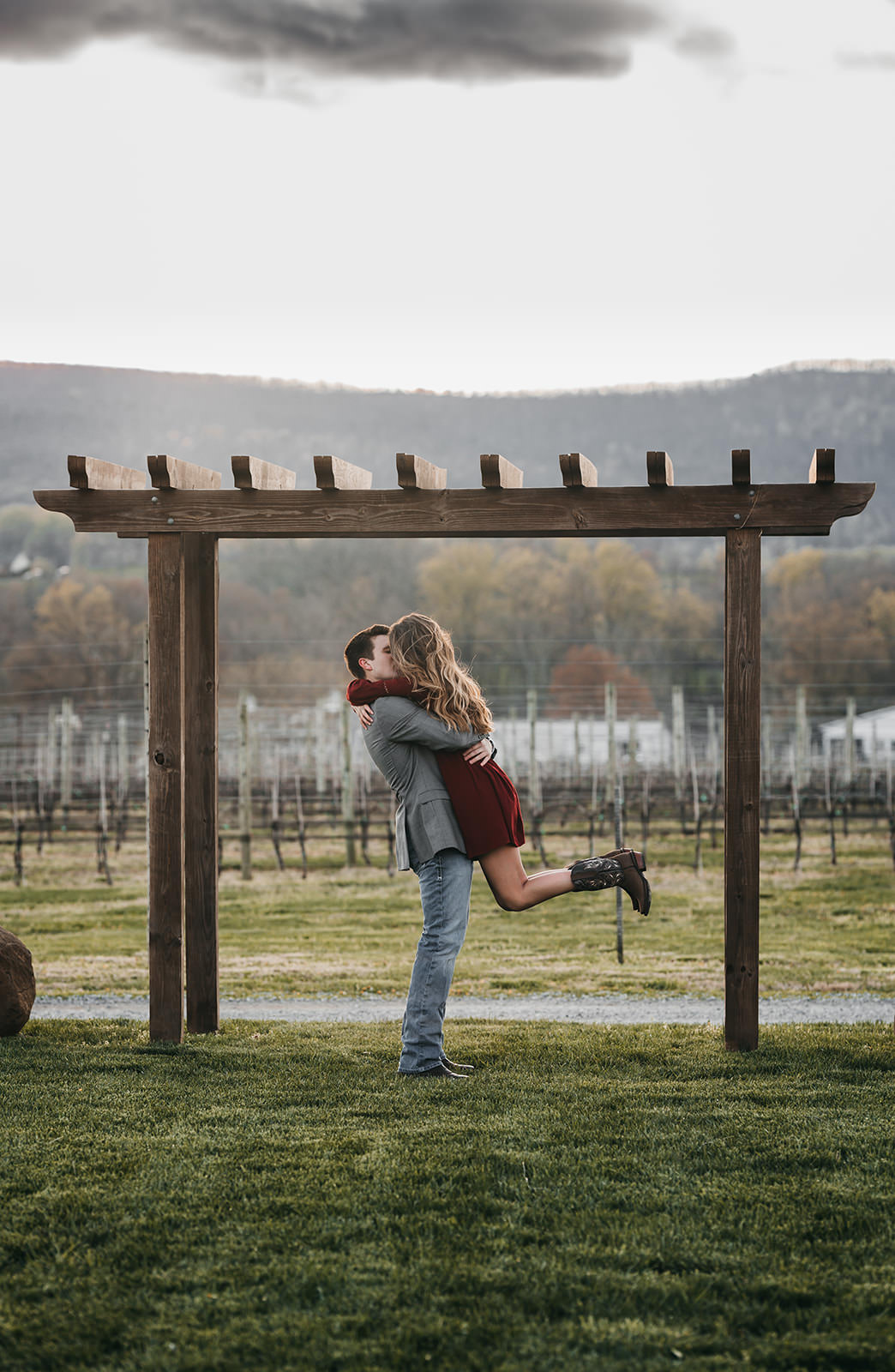 photo of a couple kissing under a trestle