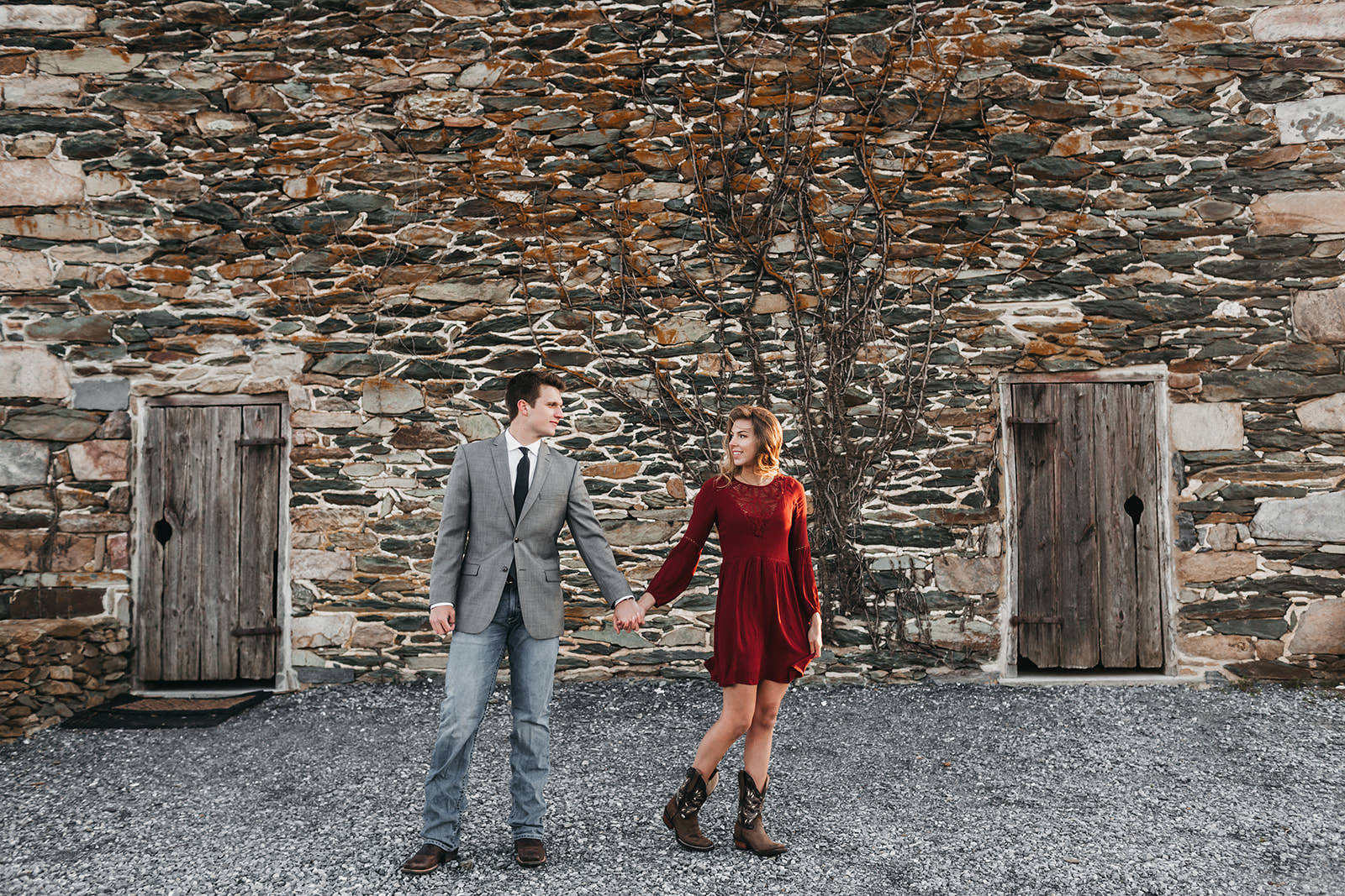 photo of a man and woman in front of a stone wall