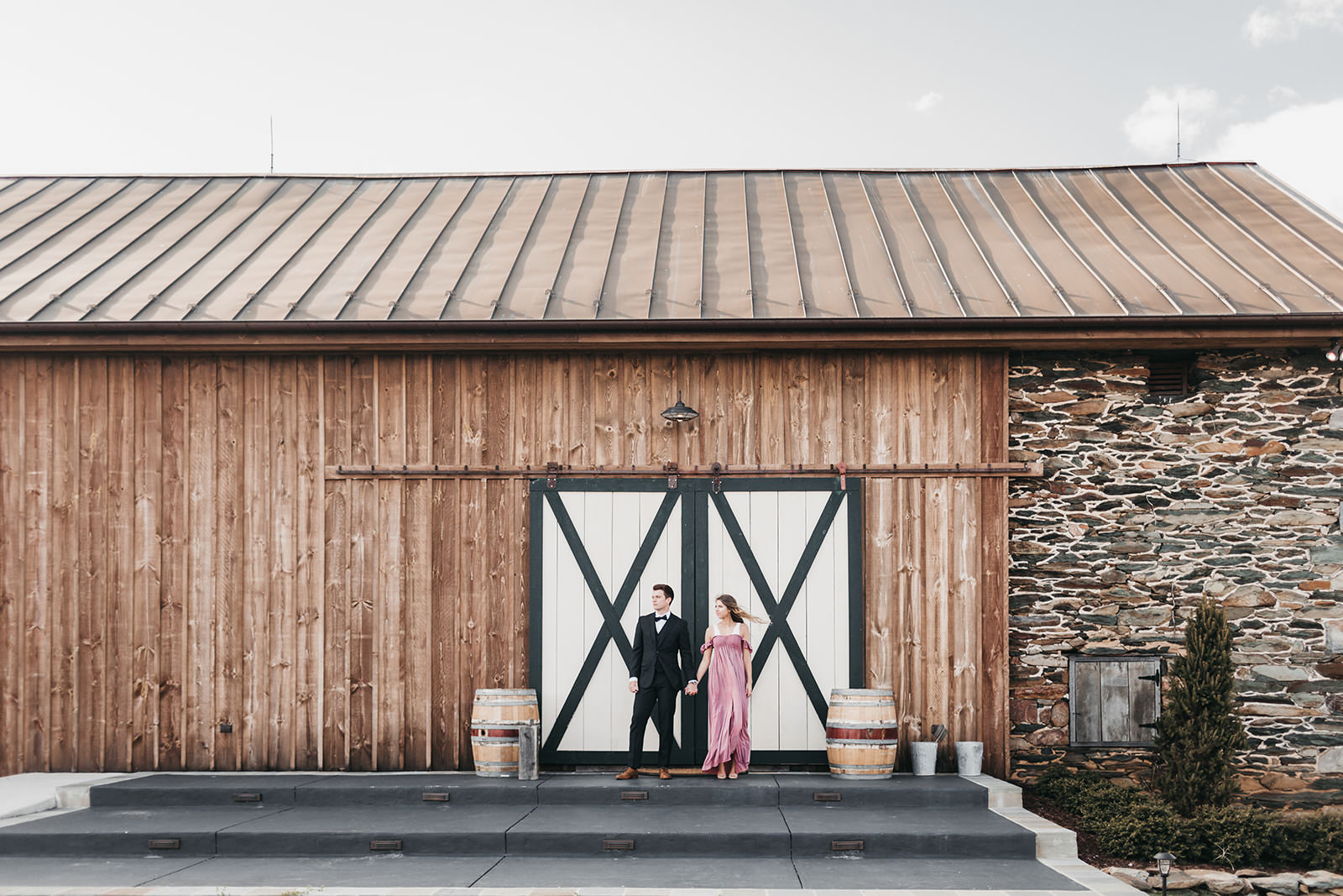 photo of a engaged couple in front of a barn