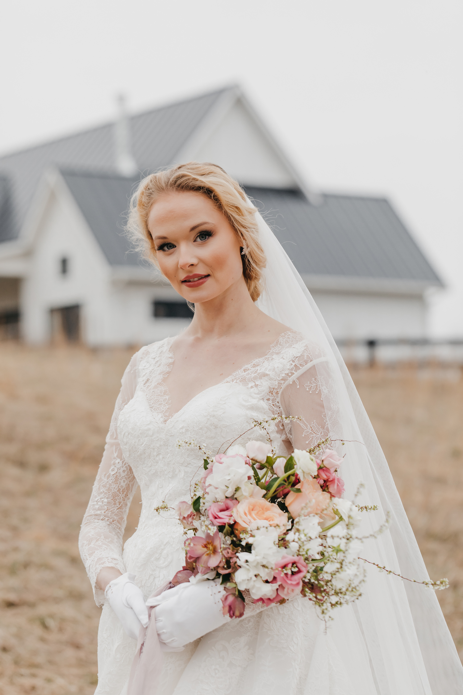 Big Spring Farm Wedding: A Complete Planning Guide. Stunning bride looking at the camera as she poses in front of the barn.