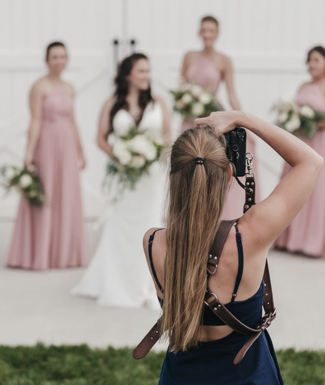The Ultimate Wedding Vendor List (Checklist Included): Photographer getting a shot of the couple at the wedding ceremony with her back to the camera.