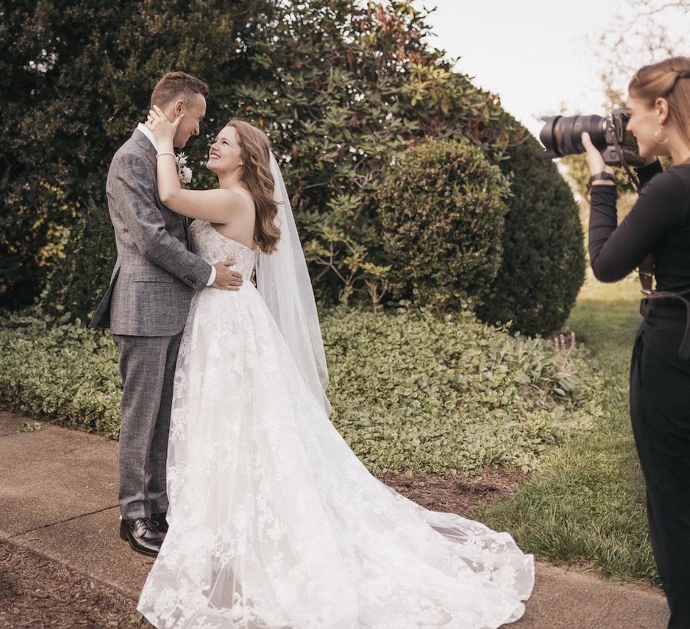 Rachel Yearick taking a shot of couple smiling at each other during their romantic wedding shoot