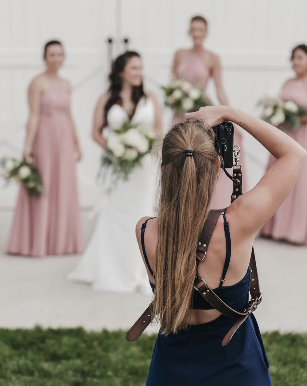 Rachel Yearick in action taking a photo of the bride with her bridesmaids at a wedding shoot