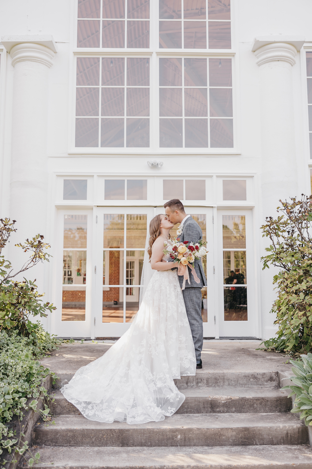 Bride and groom sharing a kiss in front of their wedding venue, captured by Rachel Yearick Photography