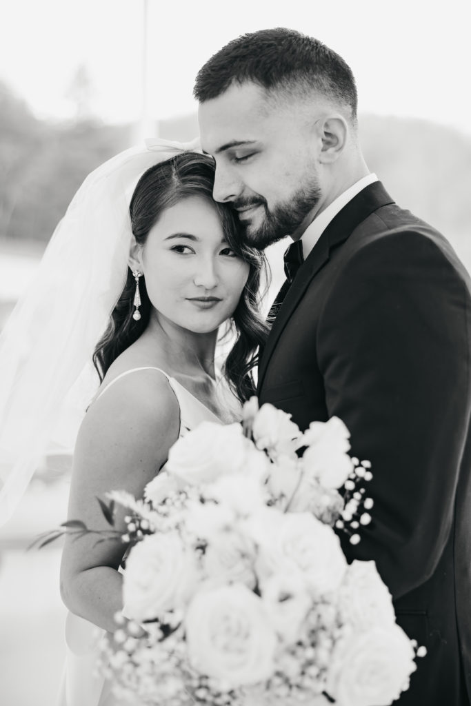 How Much Should A Wedding Photographer Cost. Black and white photo of bride and groom sharing an embrace.