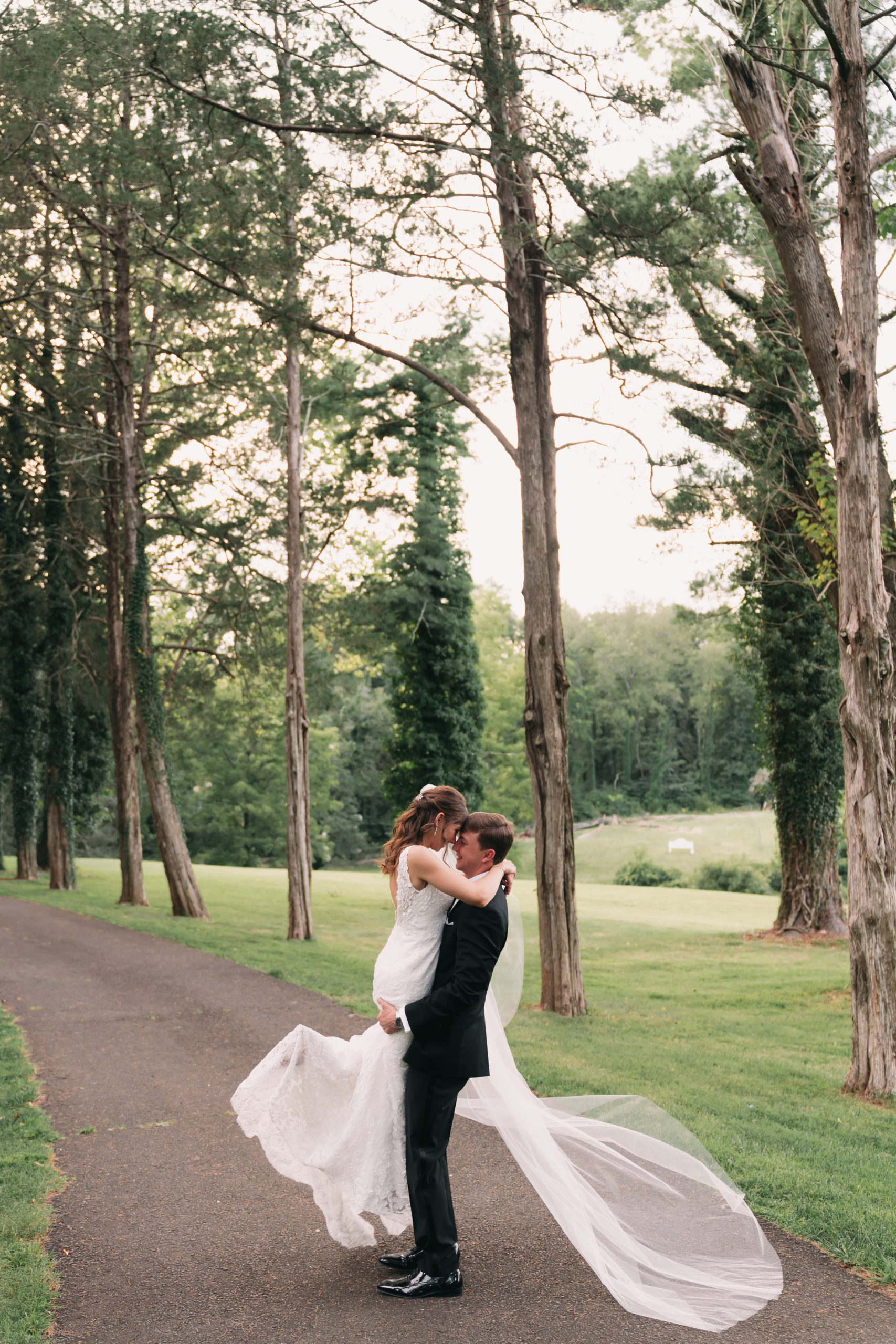 Groom lifts bride up as they share an embrace, taken by Rachel Yearick Photography