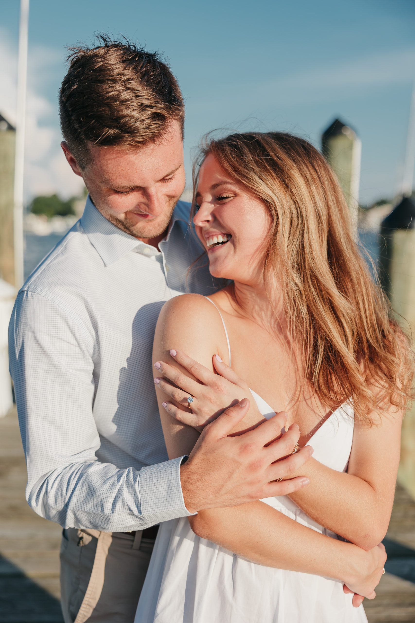 Engaged couple sharing an embrace and candidly laughing together, captured by Rachel Yearick Photography