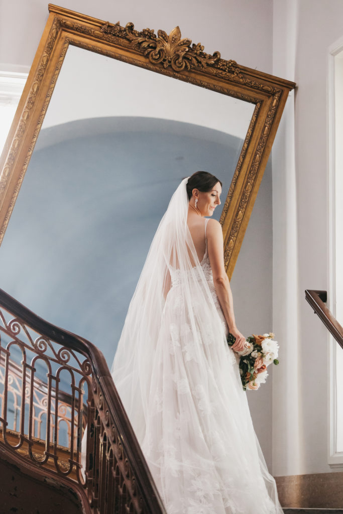 What To Look For In A Luxury Fine Art Wedding Photographer. Bride looking down with bride's sheer veil over her shoulder.