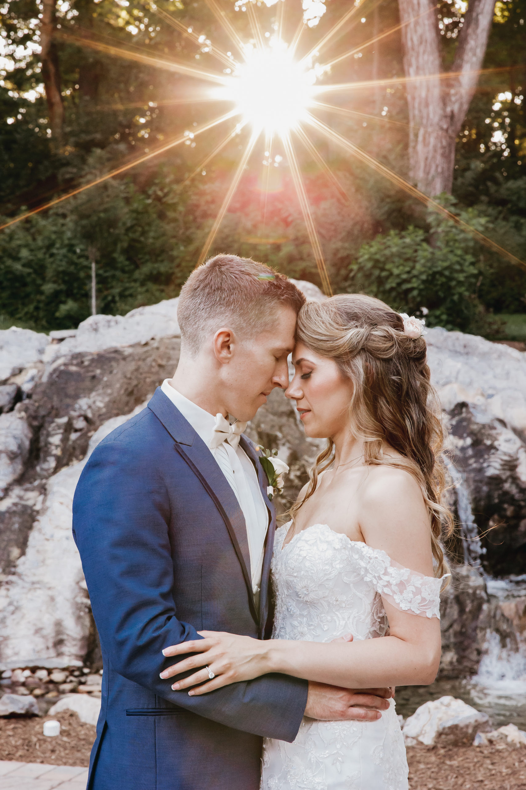 Couple sharing an embrace with light shining behind them, taken by Rachel Yearick Photography
