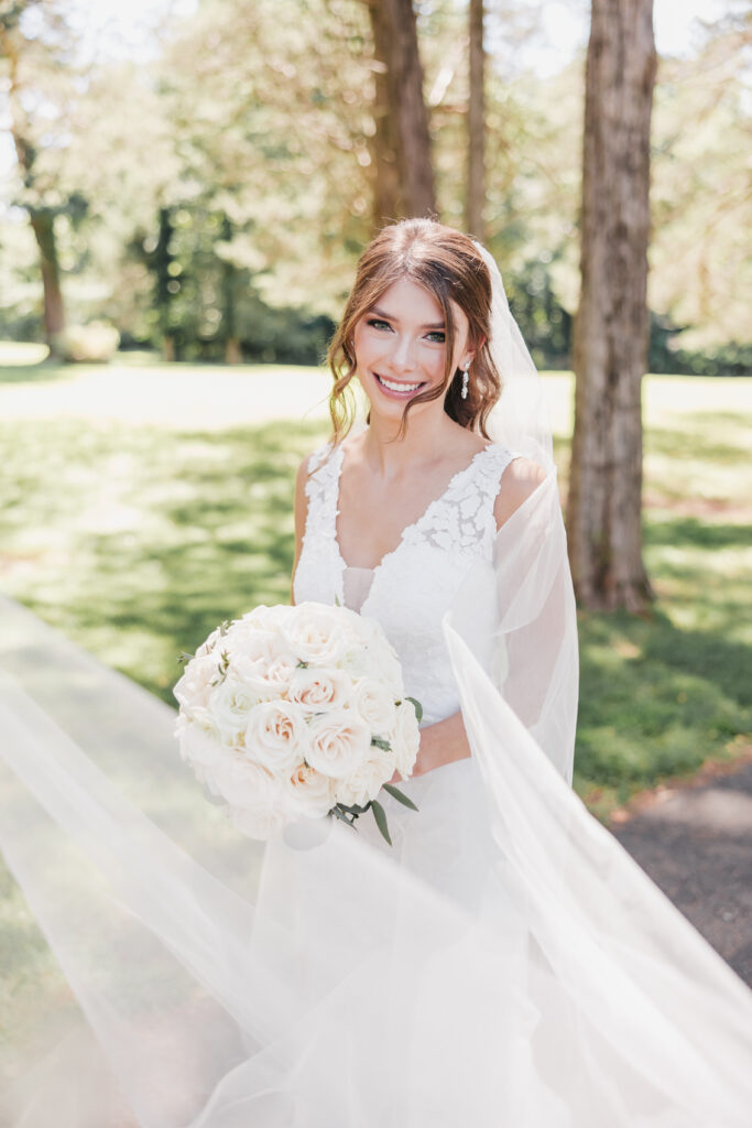 Bride smiling at the camera in her elegant dress and bouquet, captured by Rachel Yearick Photography