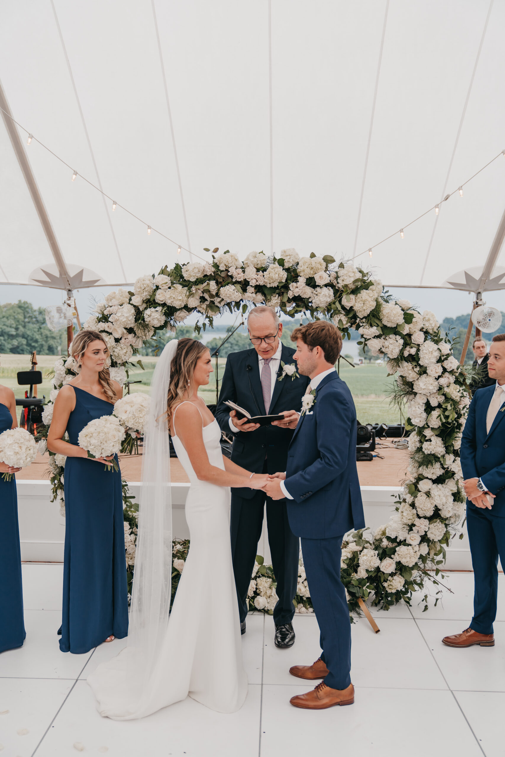 The Perfect 5 Christian Wedding Traditions For Your Big Day. Bride and groom holding hands during their wedding ceremony.