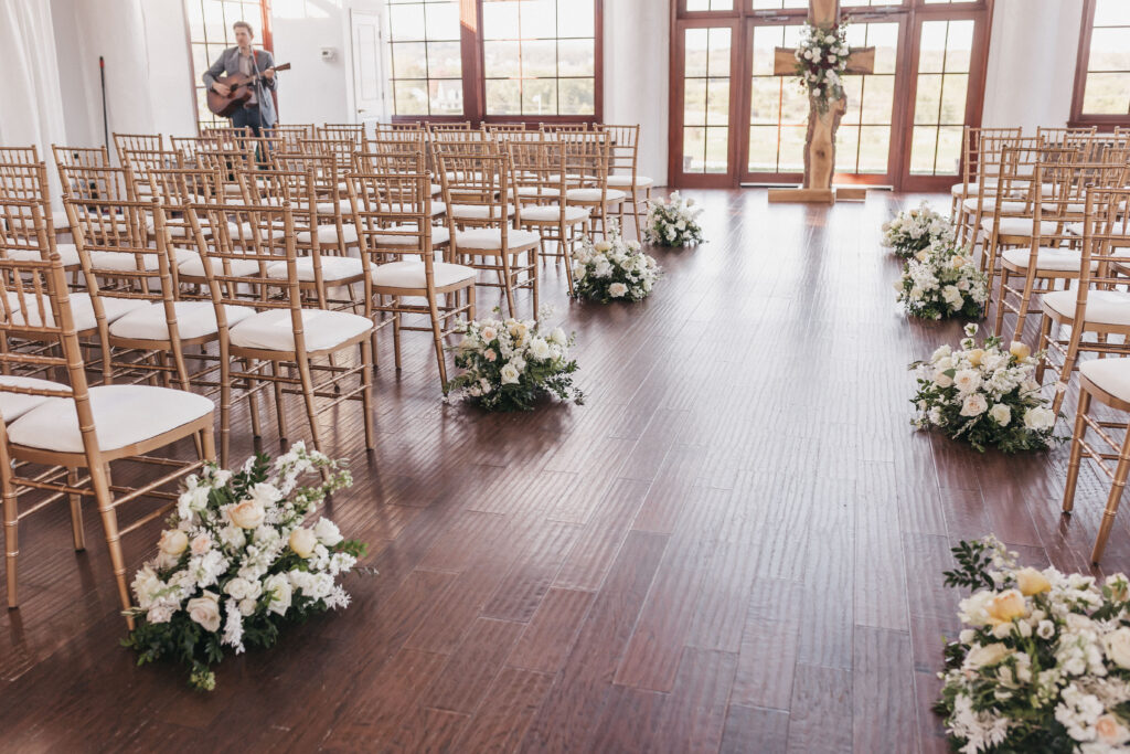 Raspberry Plain Manor Wedding Cost Breakdown and Planning Guide. Wedding ceremony venue with rows of chairs, floral arrangements and guitarist.