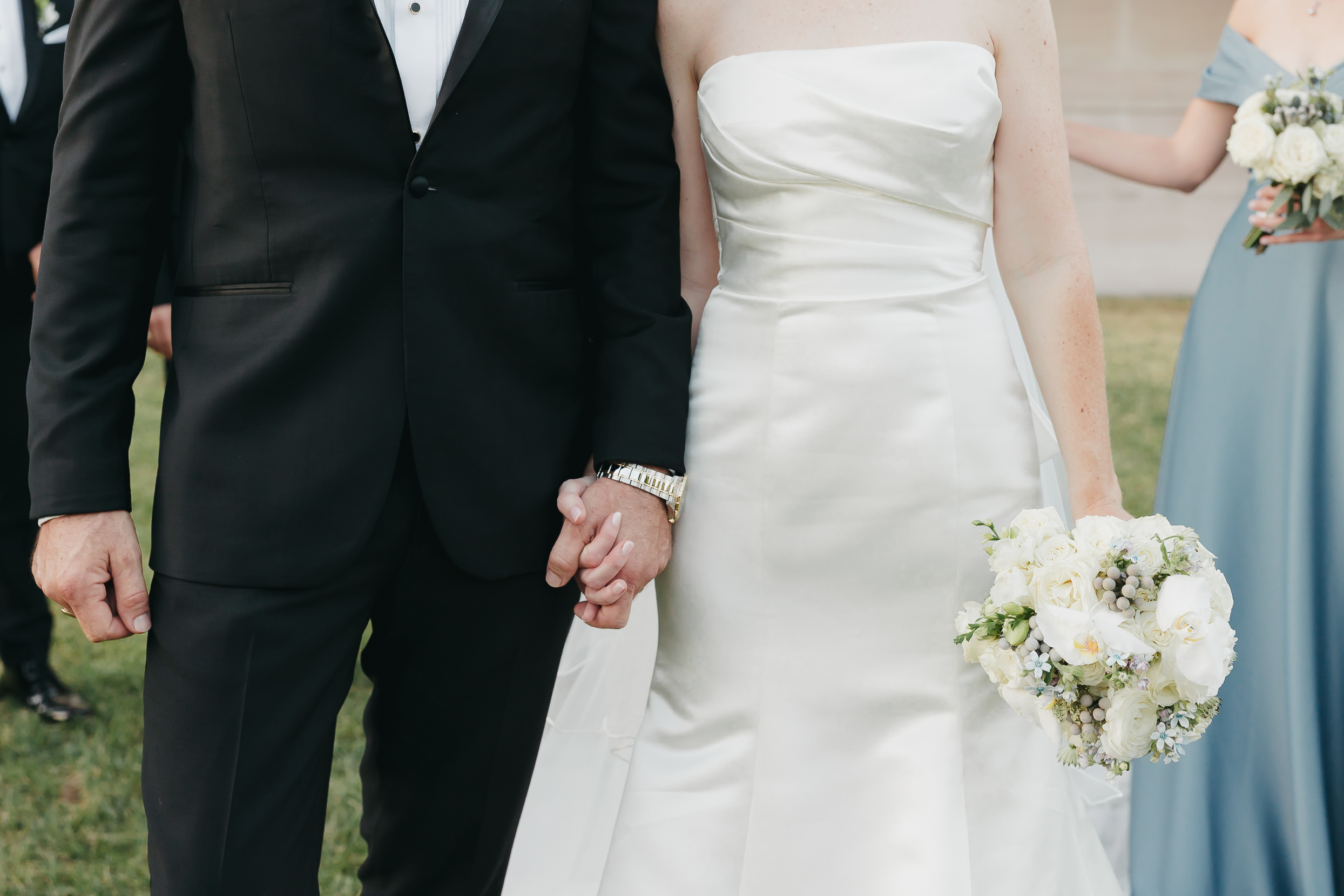 Close-up shot of bride and groom holding hands, captured by Rachel Yearick Photography