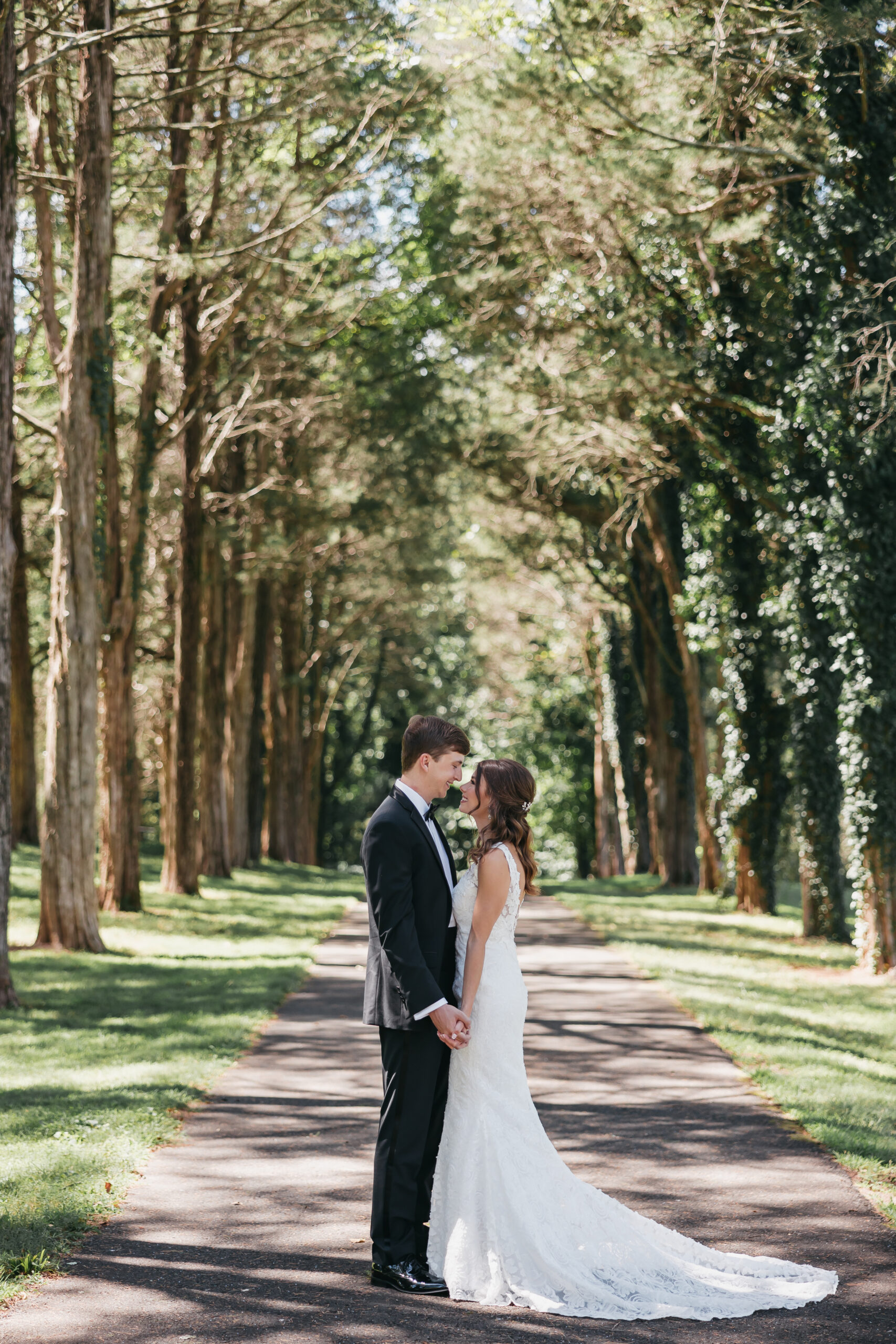 Bride and groom posing with each other on path, taken by Rachel Yearick Photography