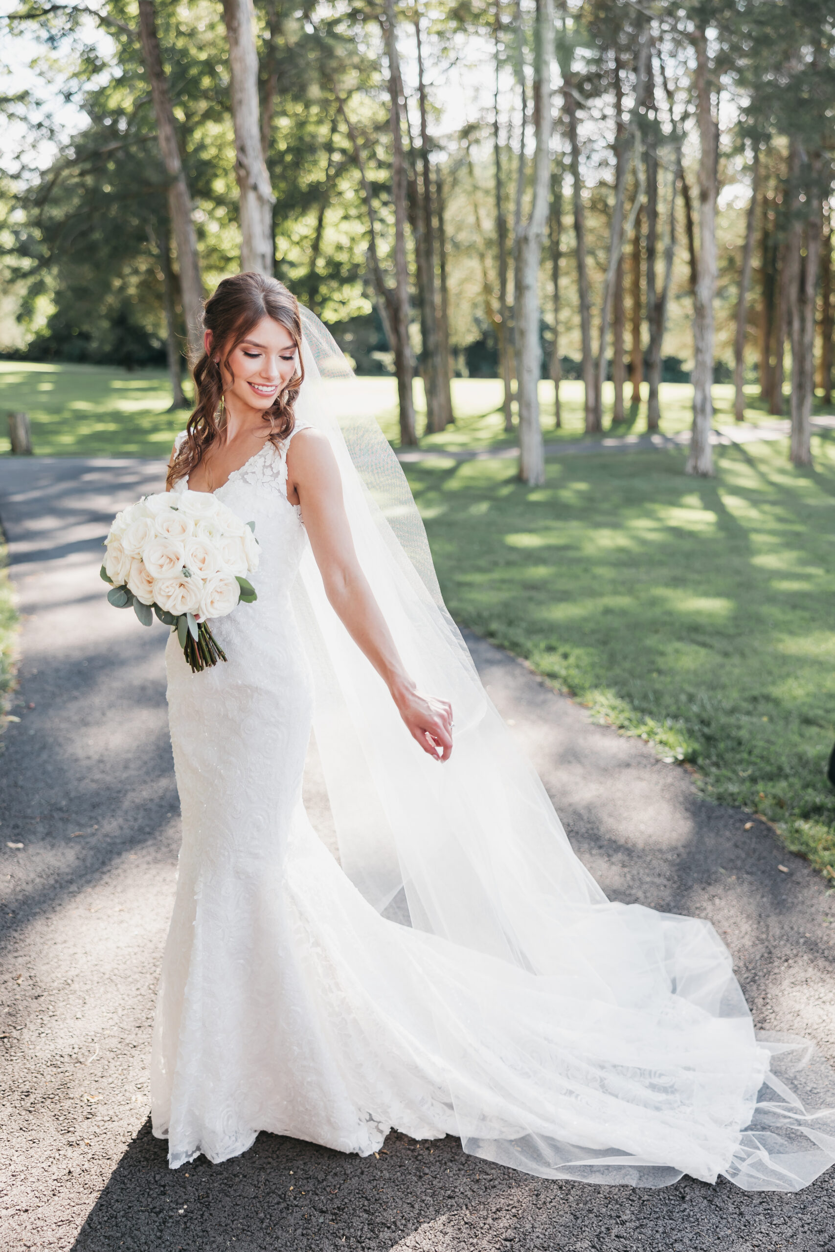Bride posing with her elegant dress and white floral bouquet, captured by Rachel Yearick Photography