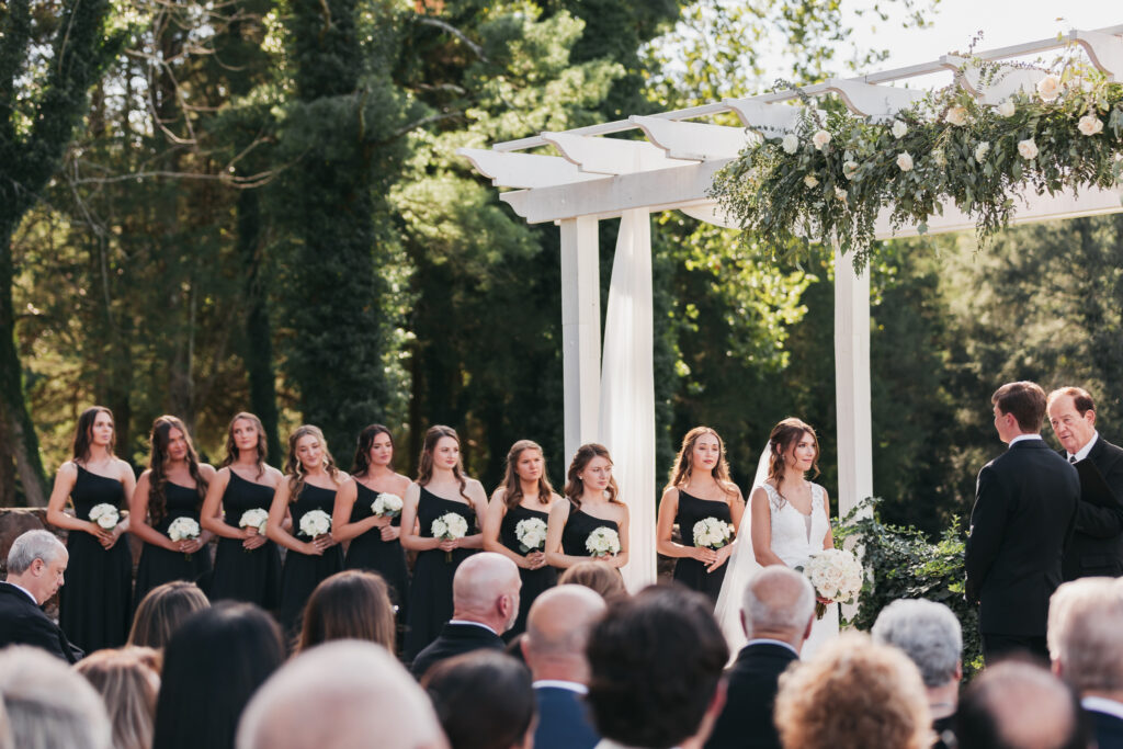 Bridesmaids standing during a beautiful black and white wedding ceremony