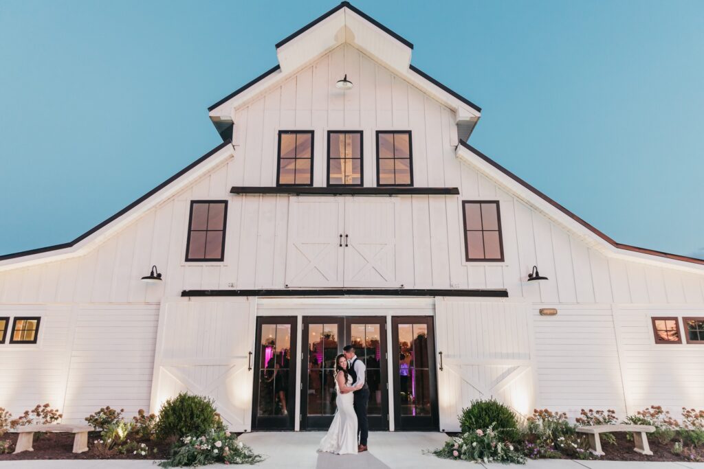Couple standing in front of the The Barn at Willowbrook Wedding Venue in Leesburg, Virginia.