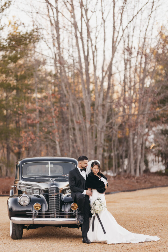 Bride and Groom standing next to a vintage car