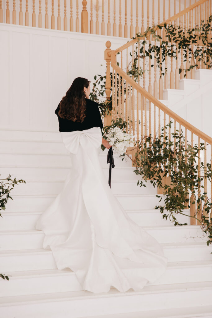 bride walking up the stairs with an elegant bow
