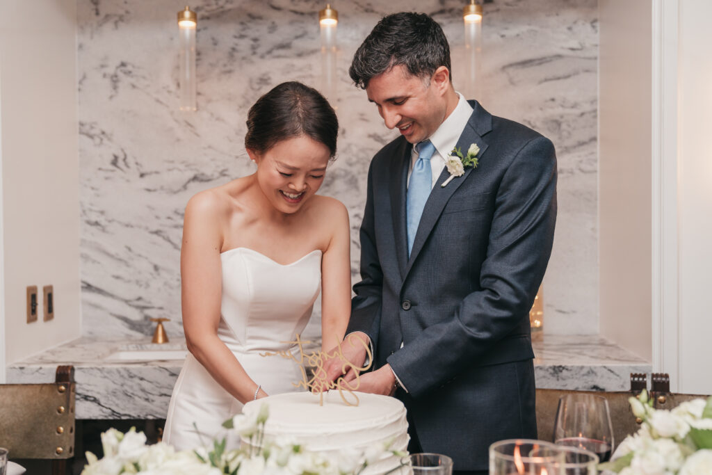 bride and groom cutting their cake together on their wedding day
