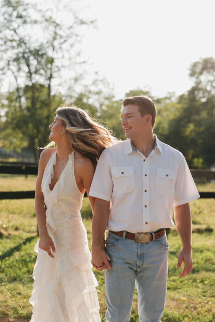 Joyful couple walking during their late-summer engagement session in the Virginia countryside
