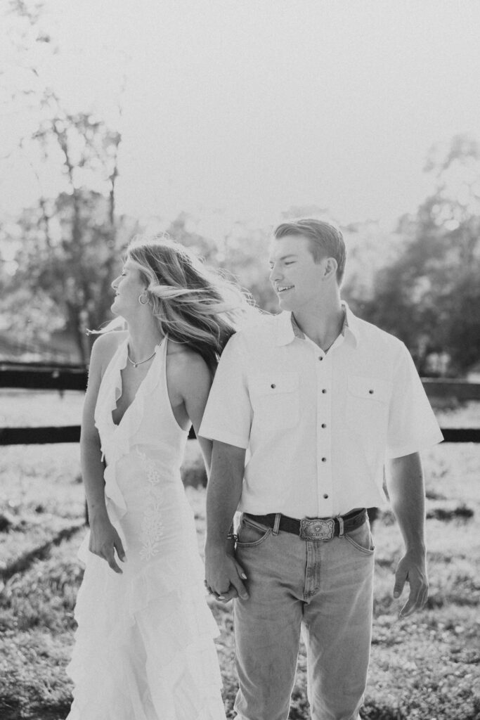 Joyful couple walking during their late-summer engagement session in the Virginia countryside