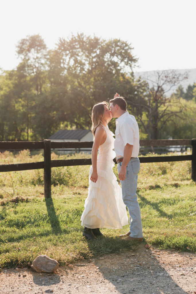Romantic engagement photo capturing elegant western charm with fence in Bluemont, Virginia