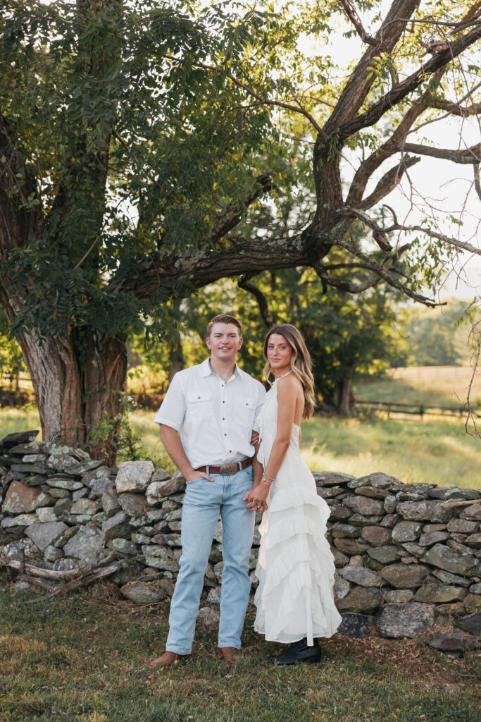 Refined western-style engagement outfit inspiration — white ruffled dress and boots for her, crisp shirt and denim for him