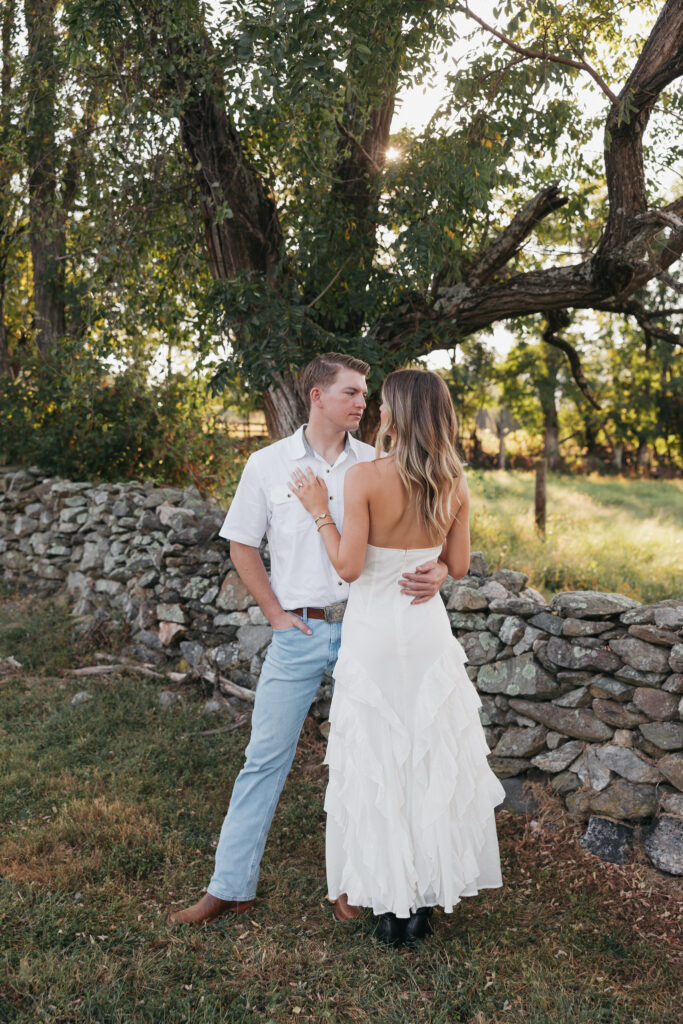 Refined western-style engagement outfit inspiration — white ruffled dress and boots for her, crisp shirt and denim for him