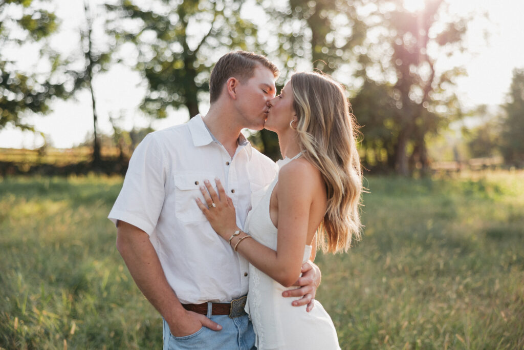 Sunset engagement photo of Olivia and Andrew holding hands in an open field — a timeless Virginia countryside moment.