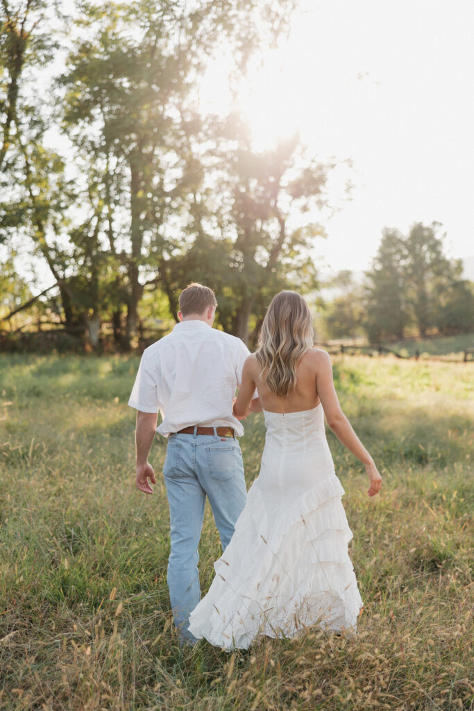 Refined western-style engagement outfit inspiration — white ruffled dress and boots for her, crisp shirt and denim for him
