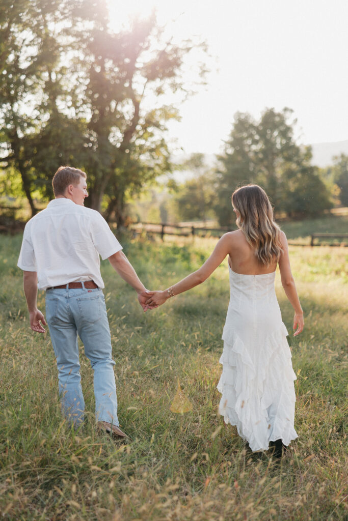 Refined western-style engagement outfit inspiration — white ruffled dress and boots for her, crisp shirt and denim for him