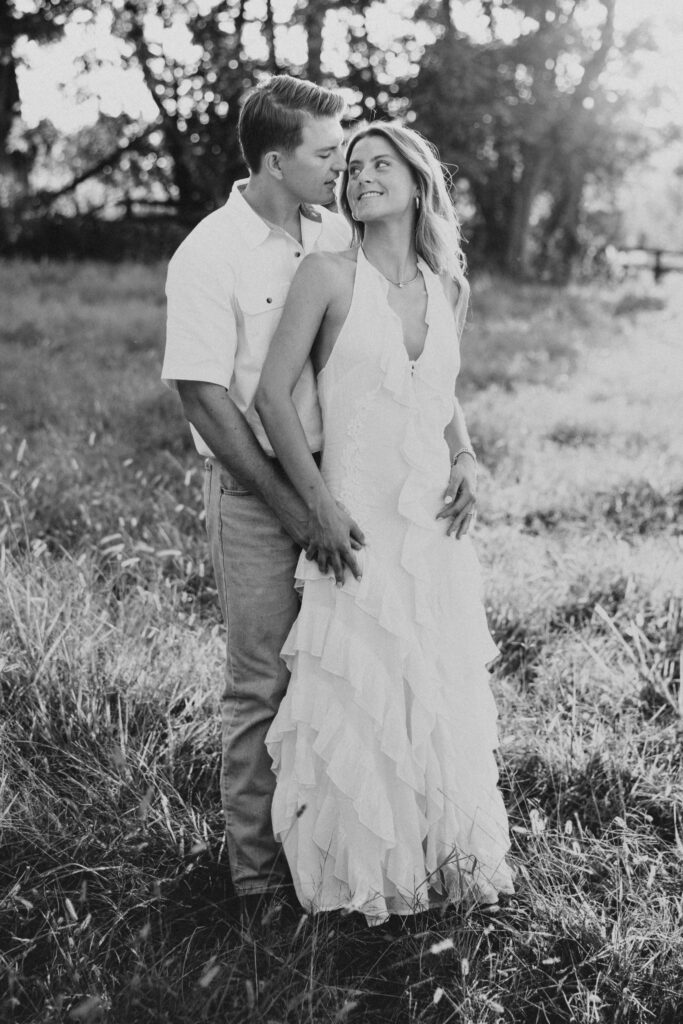 Joyful couple laughing together during their late-summer engagement session in the Virginia countryside.
