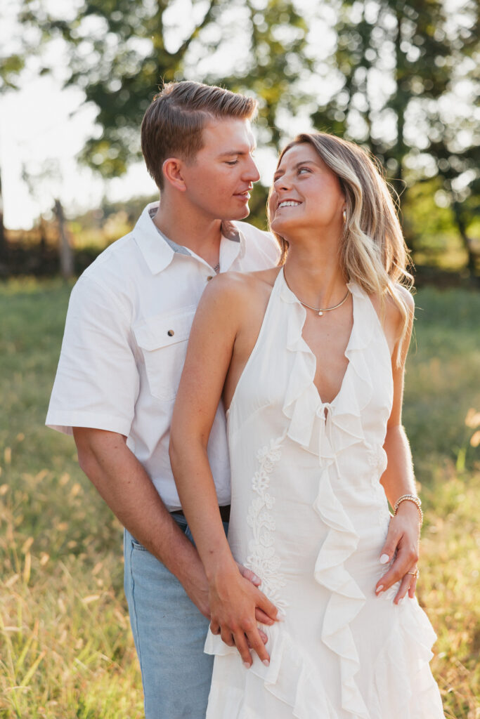 Joyful couple laughing together during their late-summer engagement session in the Virginia countryside.
