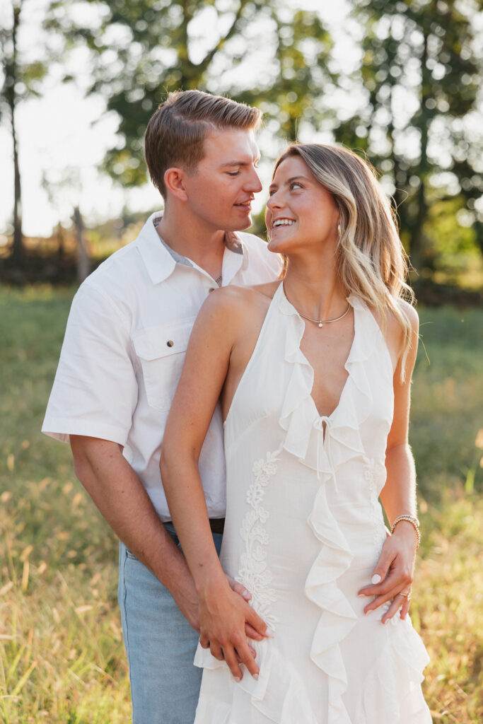 Joyful couple laughing together during their late-summer engagement session in the Virginia countryside.