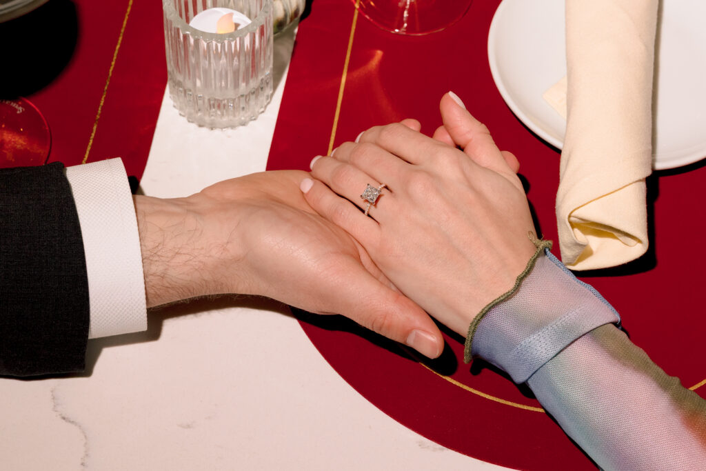 Donald placing engagement ring on Nicole's finger during winter proposal