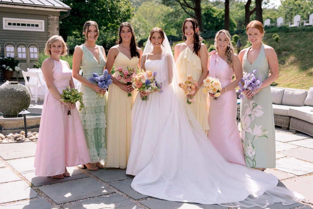 Bride and bridesmaids in colorful mismatched dresses at Tranquility Farm wedding