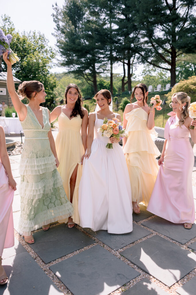 Bride and bridesmaids in colorful mismatched dresses at Tranquility Farm wedding