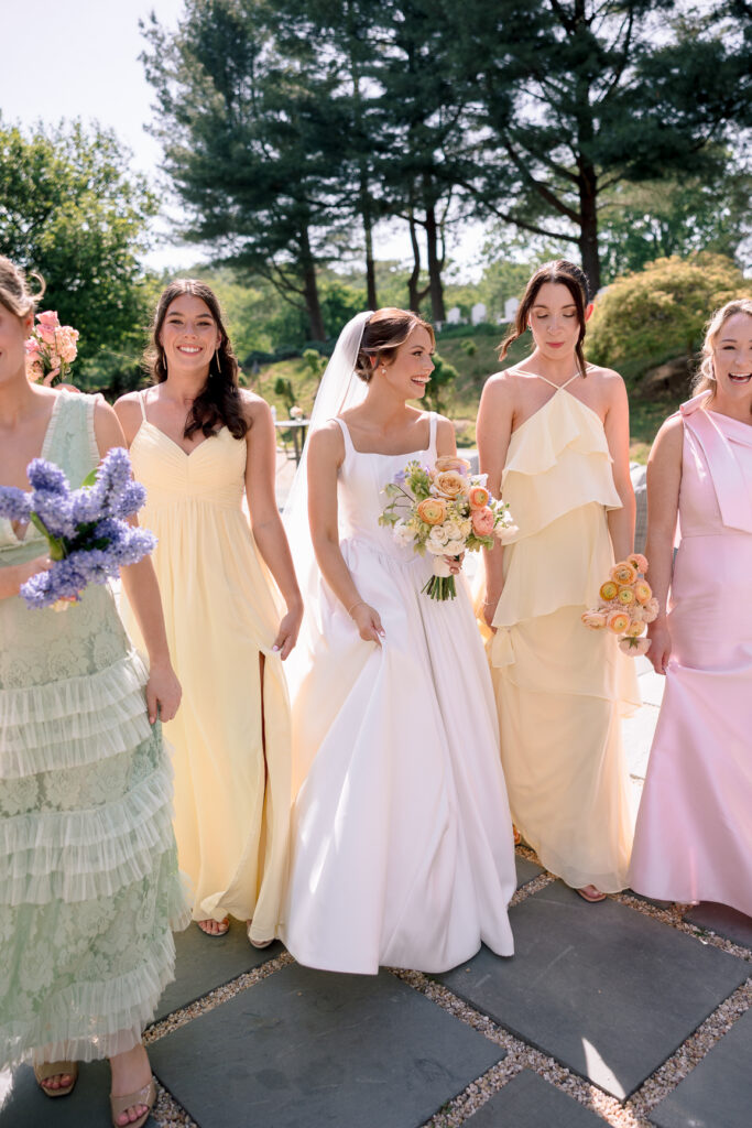 Bride and bridesmaids in colorful mismatched dresses at Tranquility Farm wedding